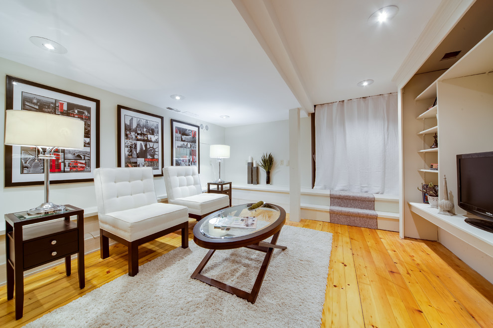 Modernes Wohnzimmer ohne Kamin mit weißer Wandfarbe, braunem Holzboden und gelbem Boden in Toronto