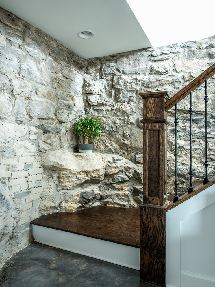 This is an example of a large traditional walk-out basement in Nashville with concrete flooring, a standard fireplace, a brick fireplace surround and grey floors.