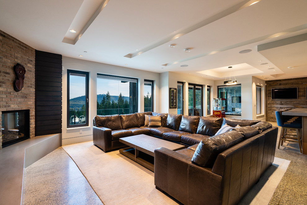 This is an example of an expansive traditional walk-out basement in Vancouver with white walls, concrete flooring, a standard fireplace, a brick fireplace surround and grey floors.