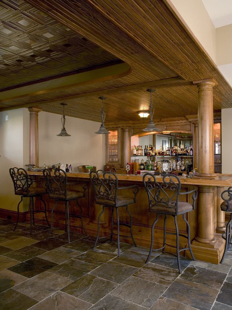 Esempio di un'ampia taverna chic seminterrata con pavimento in ardesia, pareti beige e pavimento grigio