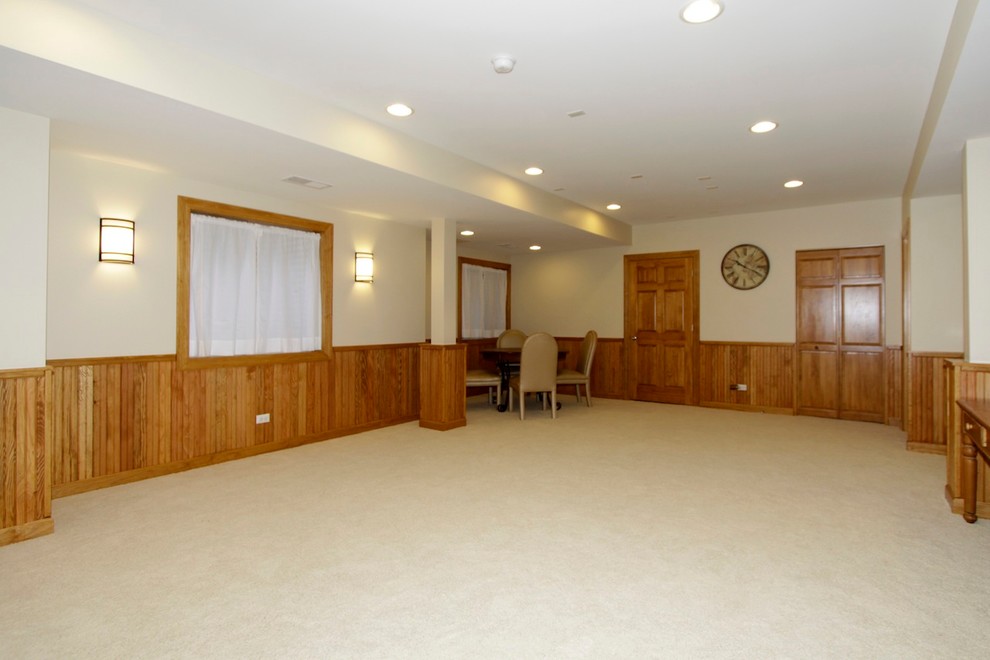 Example of a large classic underground carpeted basement design in Chicago with beige walls