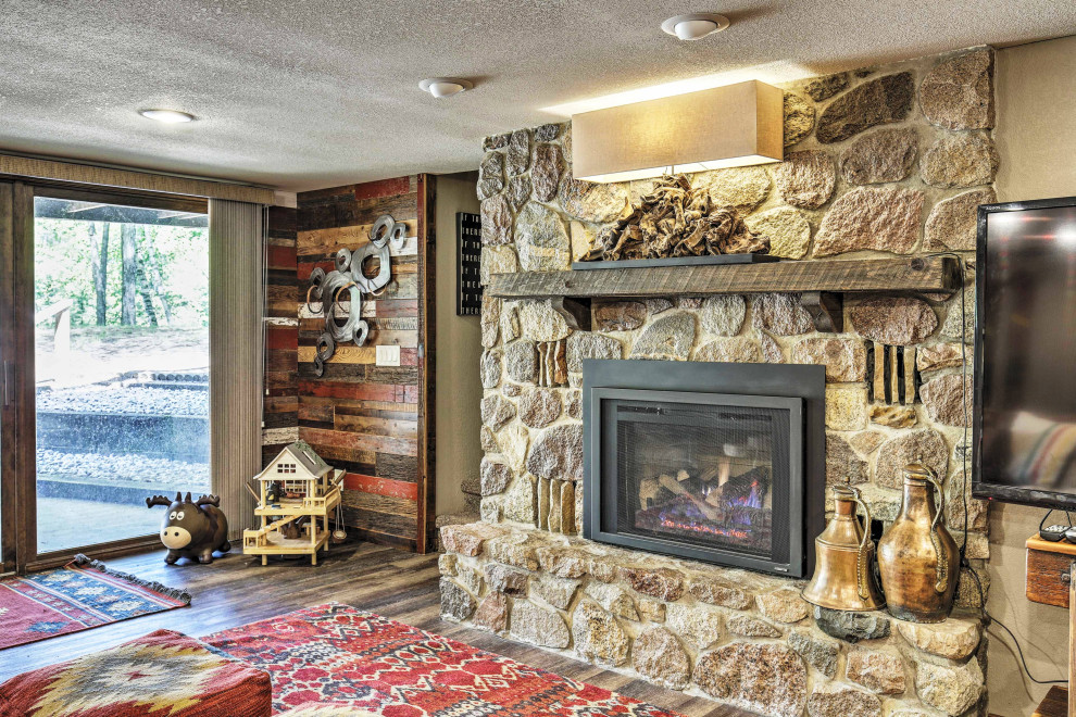 Mid-sized mountain style walk-out vinyl floor and brown floor basement photo in Other with multicolored walls, a standard fireplace and a metal fireplace