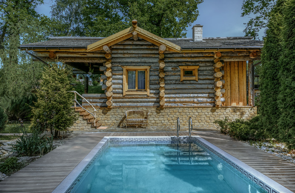 Exemple d'une piscine rectangle avec une terrasse en bois.