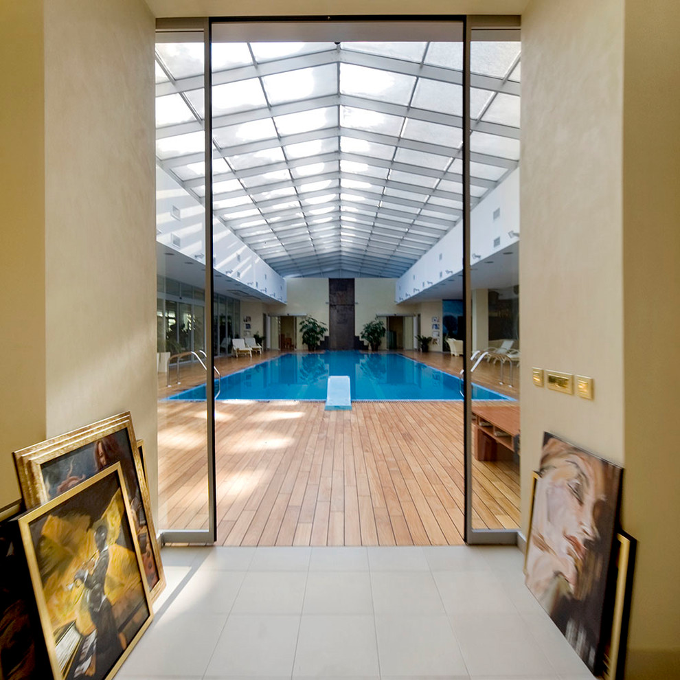 На фото: огромный спортивный, прямоугольный бассейн в доме в современном стиле с джакузи и настилом
