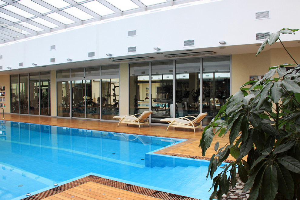 Idées déco pour une très grande piscine contemporaine rectangle avec une terrasse en bois et un bain bouillonnant.