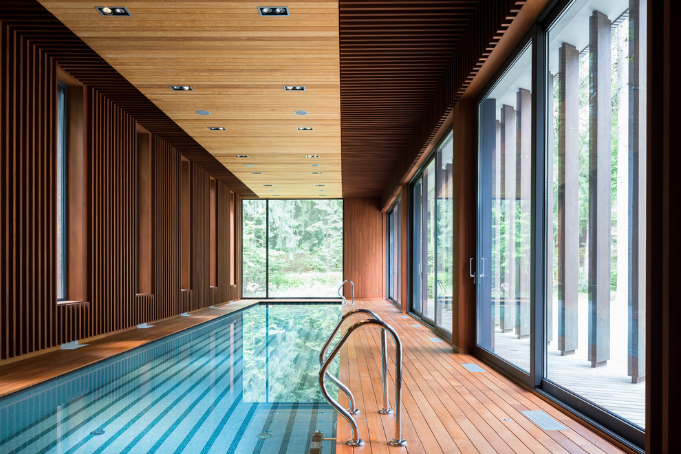 Diseño de piscina actual interior y rectangular con entablado