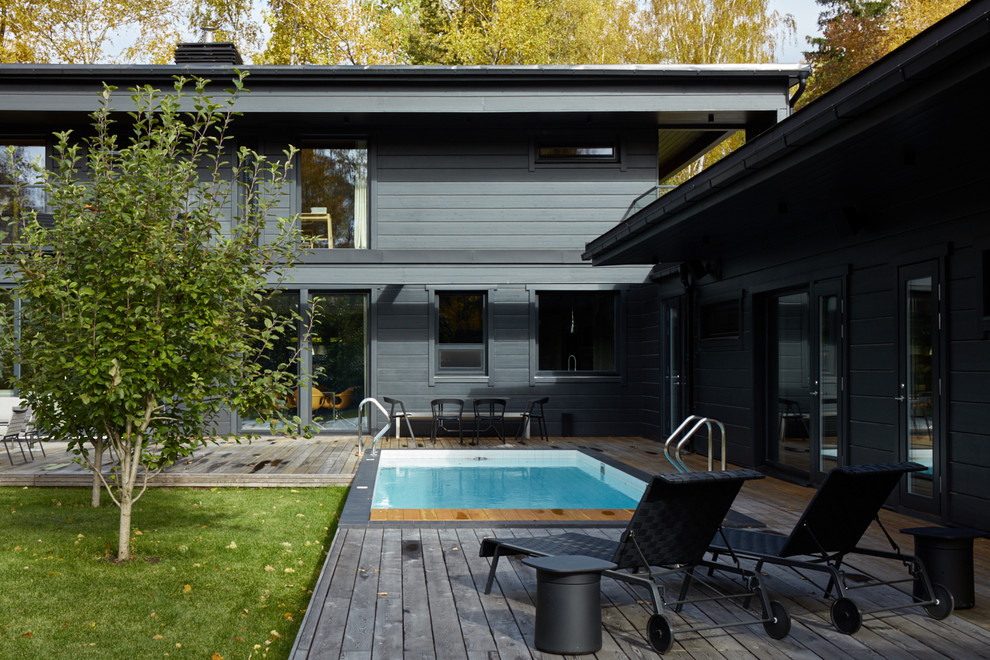 Aménagement d'une piscine latérale contemporaine rectangle avec une terrasse en bois.