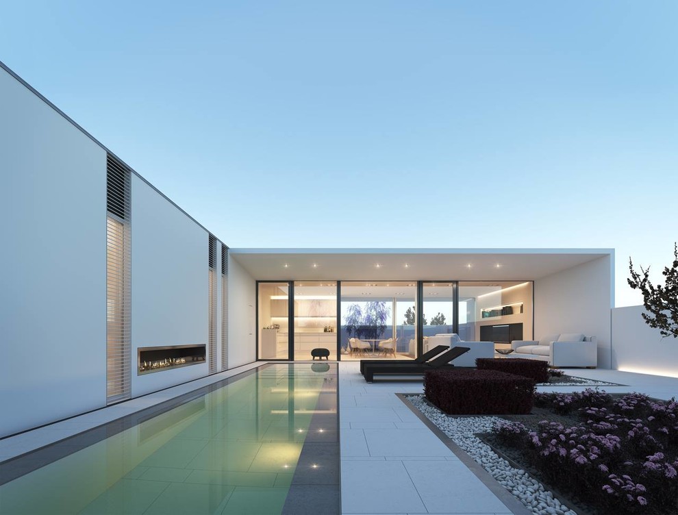 На фото: большой прямоугольный бассейн на заднем дворе в современном стиле с джакузи и покрытием из каменной брусчатки с