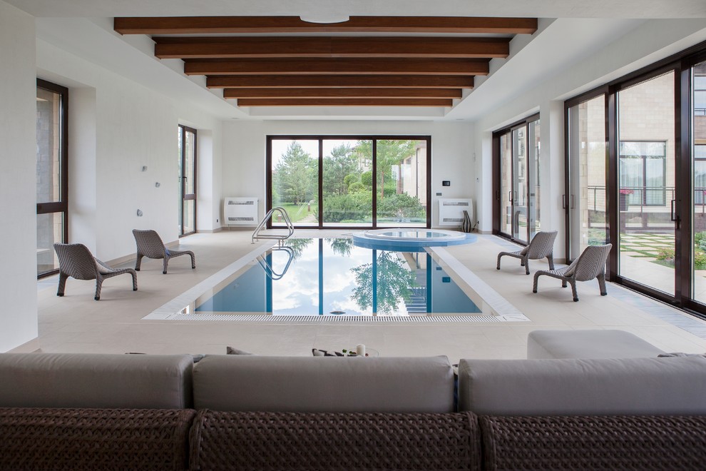 На фото: спортивный, прямоугольный бассейн в доме в стиле неоклассика (современная классика) с