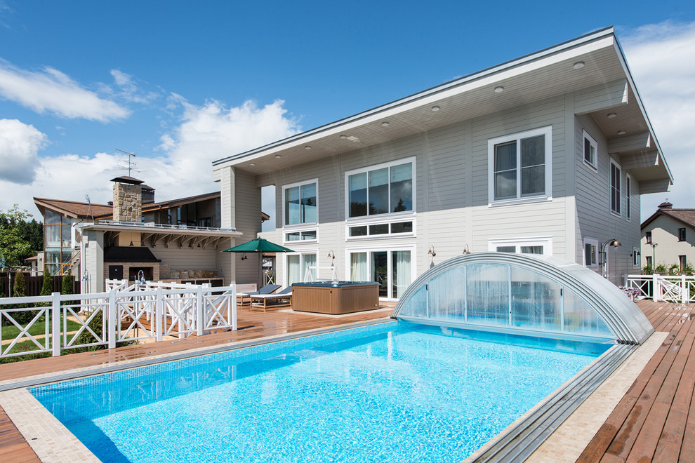 Идея дизайна: прямоугольный бассейн на заднем дворе в классическом стиле с настилом и домиком у бассейна
