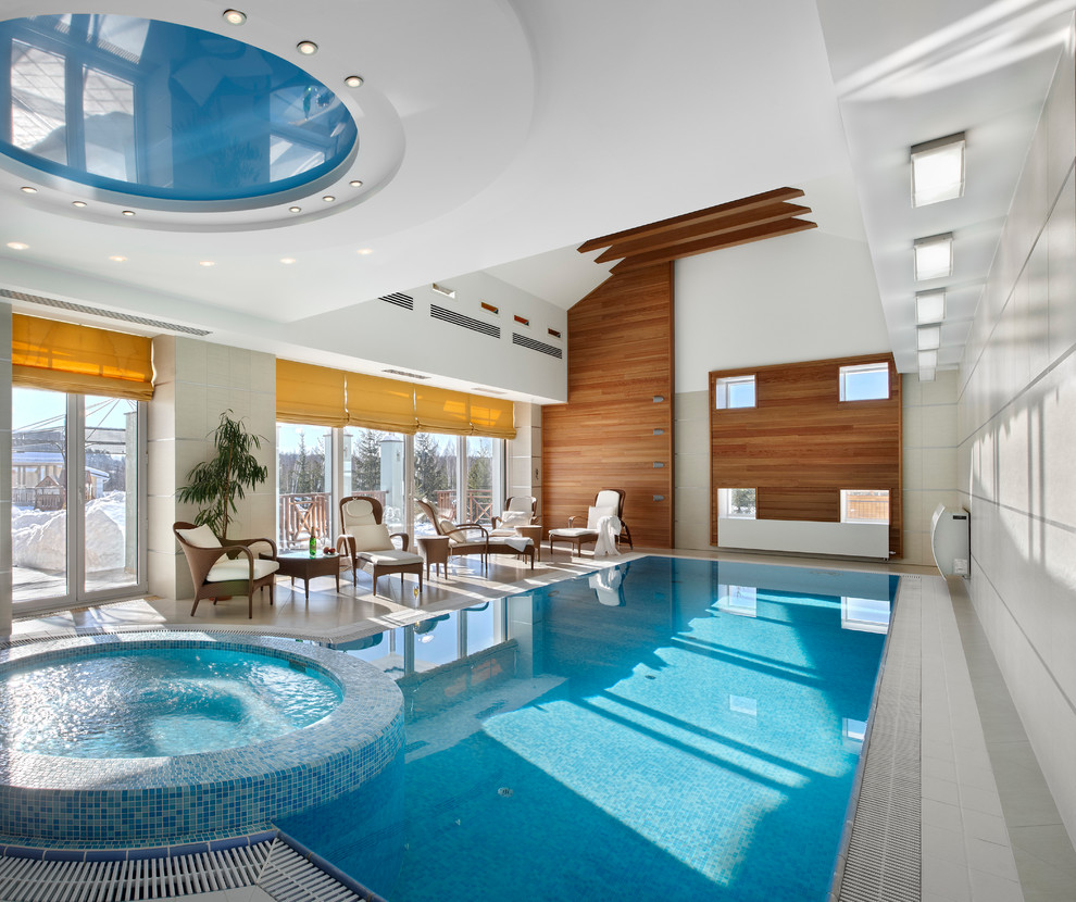 Large contemporary indoor rectangular swimming pool in Yekaterinburg with a water feature and tiled flooring.