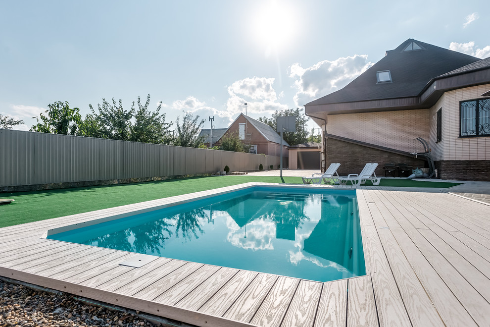 Esempio di una piscina naturale minimal rettangolare di medie dimensioni e davanti casa con una dépendance a bordo piscina e pedane