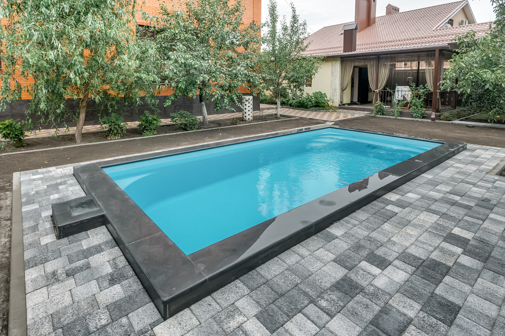 Idee per una piscina design rettangolare di medie dimensioni con pavimentazioni in cemento