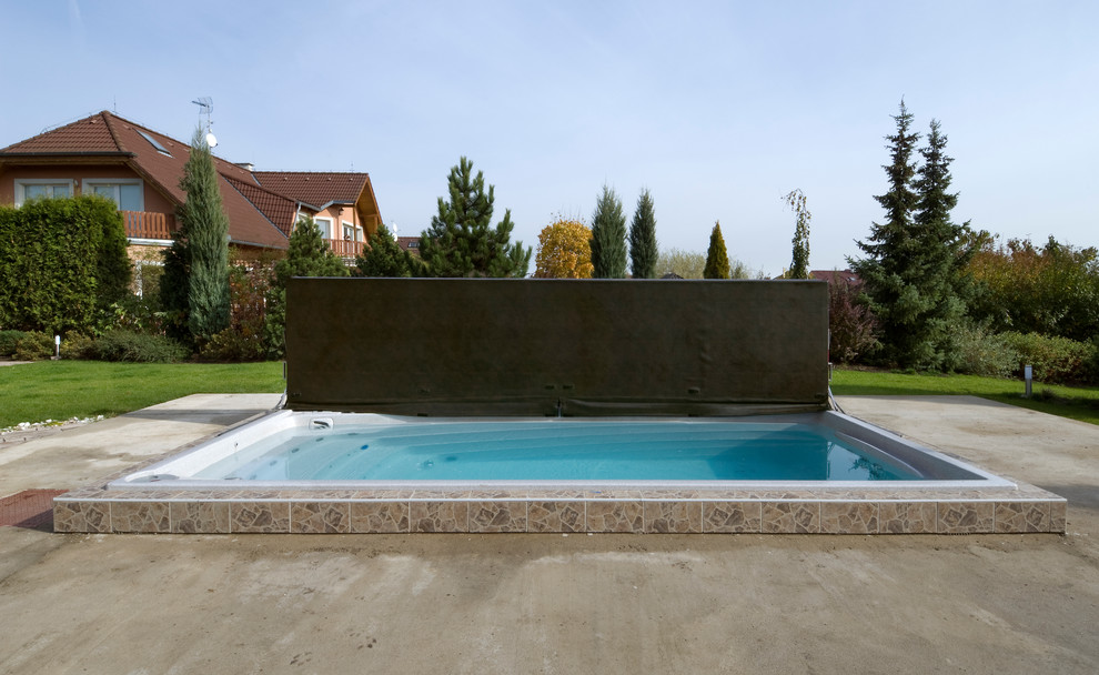 Пример оригинального дизайна: наземный, прямоугольный бассейн среднего размера на заднем дворе в современном стиле с джакузи