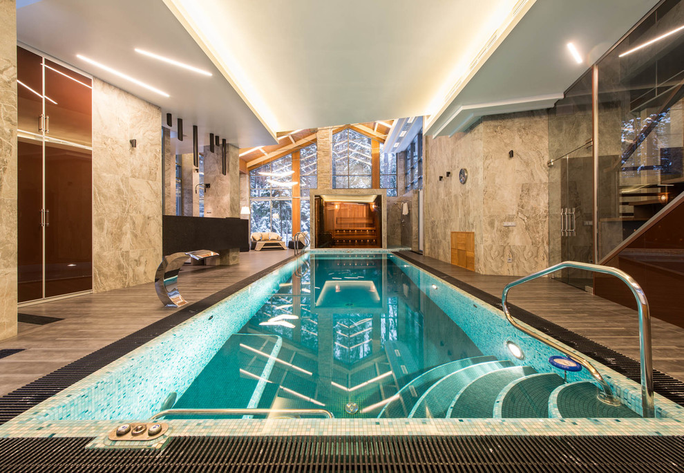 Exemple d'une piscine intérieure tendance rectangle avec une terrasse en bois.