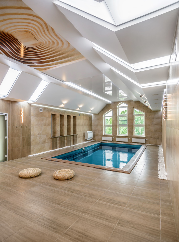Ejemplo de piscina actual interior y rectangular con suelo de baldosas