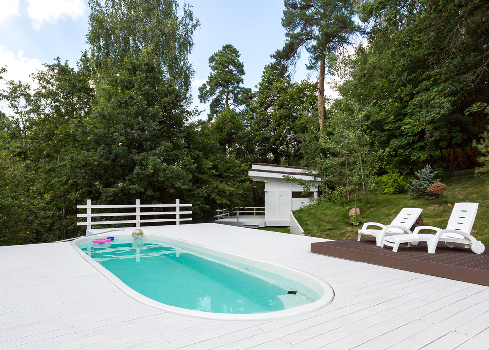 Cette photo montre une piscine arrière bord de mer avec une terrasse en bois.