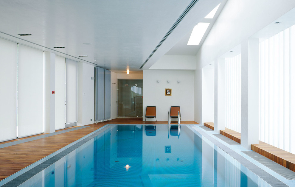 Cette photo montre une piscine intérieure tendance rectangle avec une terrasse en bois.