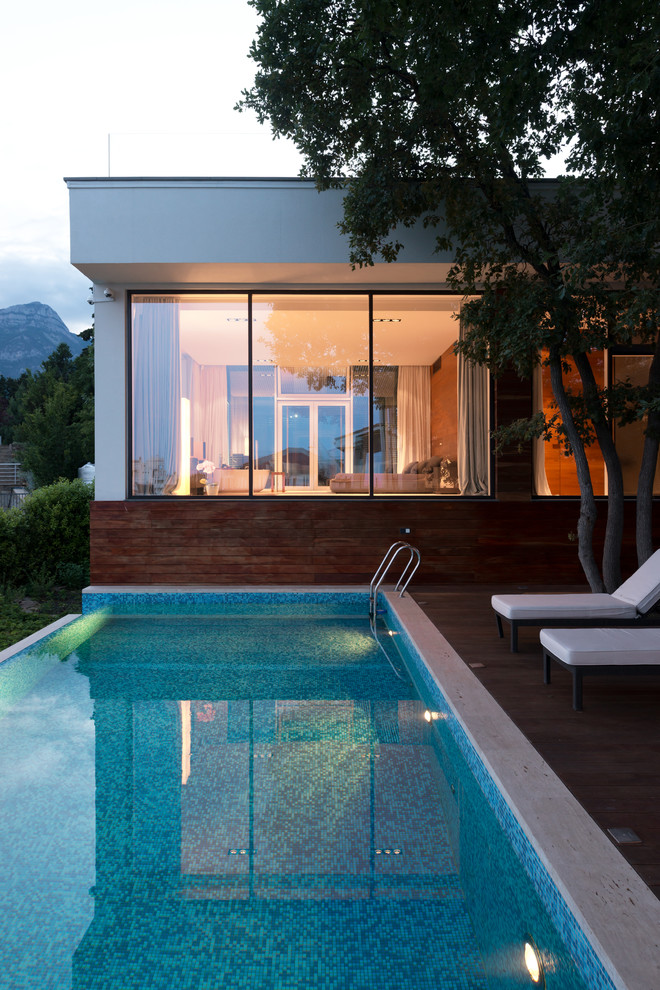 Пример оригинального дизайна: прямоугольный бассейн-инфинити среднего размера на боковом дворе в современном стиле