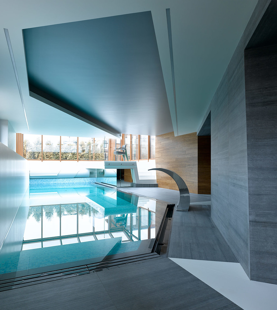 На фото: спортивный бассейн произвольной формы в доме в современном стиле с