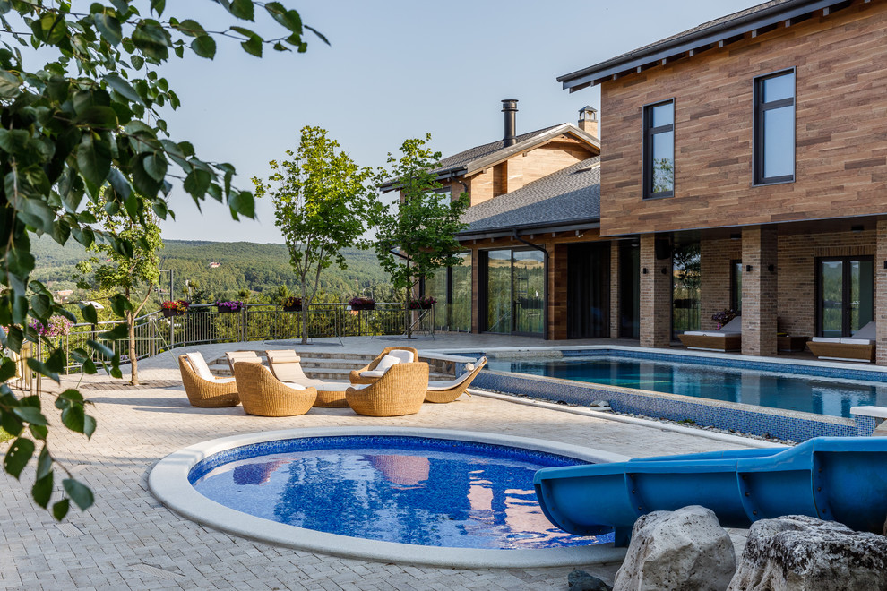 Modernes Pool im Vorgarten in runder Form mit Wasserrutsche in Sonstige