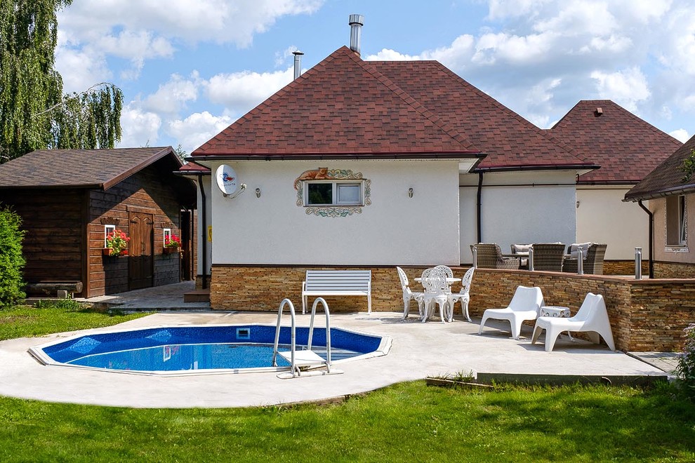 Foto de piscina infinita rústica de tamaño medio redondeada en patio lateral con losas de hormigón