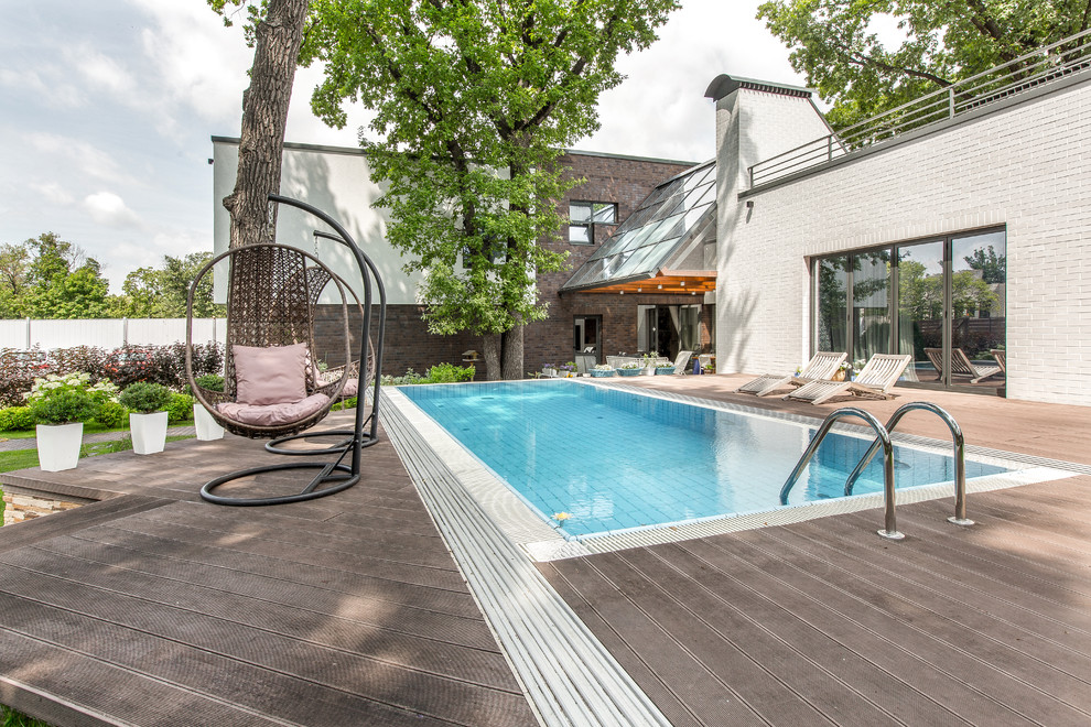 Immagine di una piscina monocorsia design rettangolare di medie dimensioni e davanti casa con pedane