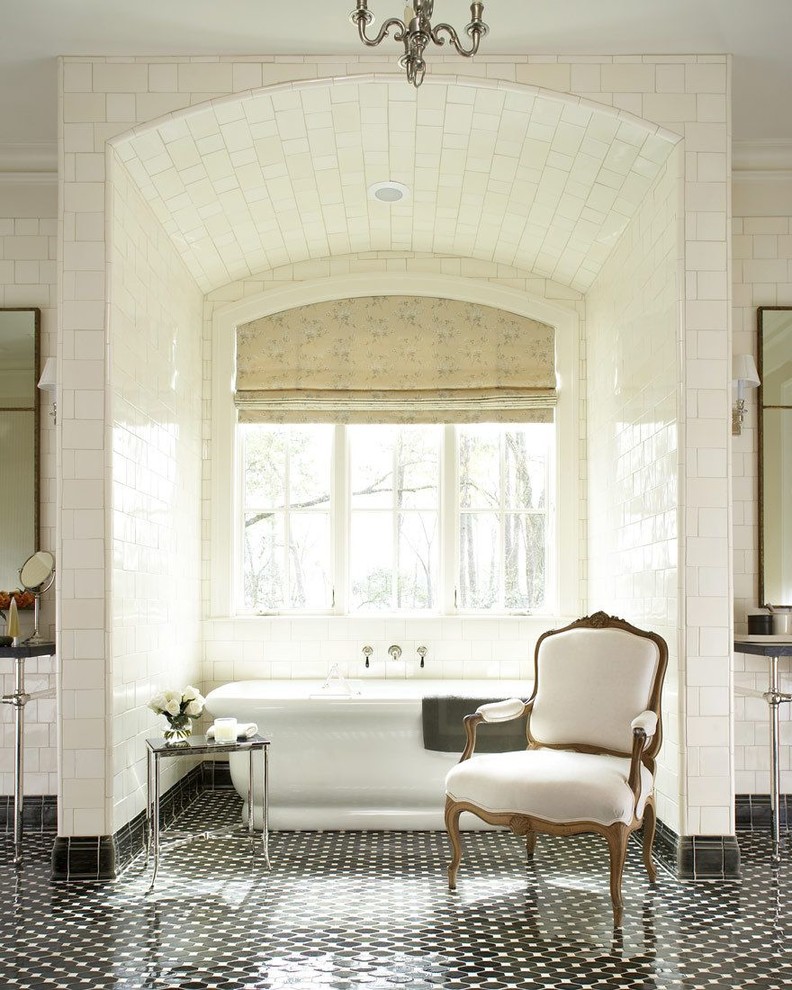 На фото: главная ванная комната в стиле неоклассика (современная классика) с отдельно стоящей ванной, белой плиткой, плиткой кабанчик, полом из мозаичной плитки и черным полом