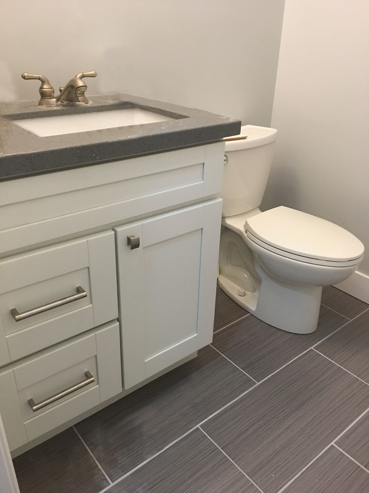 Idee per una piccola stanza da bagno moderna con ante in stile shaker, ante bianche, pareti bianche, pavimento in gres porcellanato, lavabo sottopiano, top in quarzo composito e pavimento grigio