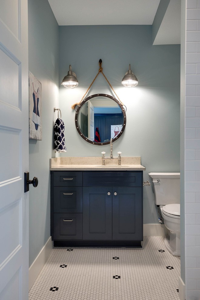 Bild på ett lantligt badrum, med skåp i shakerstil, blå skåp, en toalettstol med separat cisternkåpa, svart och vit kakel, mosaik, blå väggar, ett undermonterad handfat och granitbänkskiva