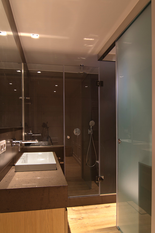 Modelo de cuarto de baño contemporáneo de tamaño medio con ducha empotrada, suelo de madera en tonos medios, aseo y ducha y lavabo sobreencimera