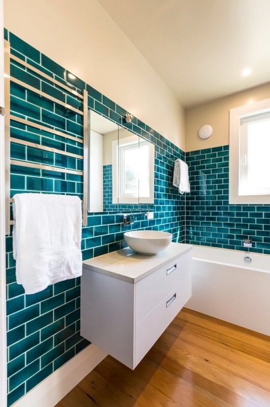 Idéer för att renovera ett mellanstort retro badrum, med släta luckor, vita skåp, ett badkar i en alkov, blå kakel, tunnelbanekakel och ett fristående handfat