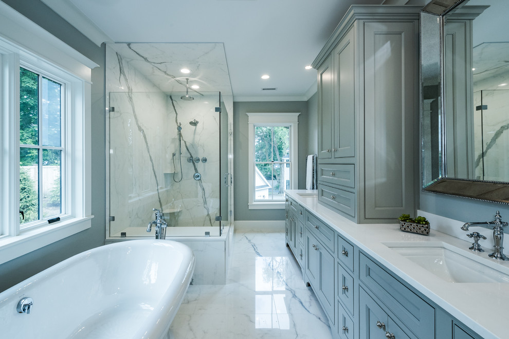 Example of a large trendy master white tile and marble tile marble floor and white floor bathroom design in Boston with recessed-panel cabinets, gray cabinets, a two-piece toilet, gray walls, a drop-in sink, solid surface countertops and a hinged shower door