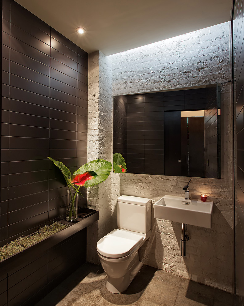 Idee per una stanza da bagno minimal con lavabo sospeso, WC a due pezzi, piastrelle nere e pareti bianche