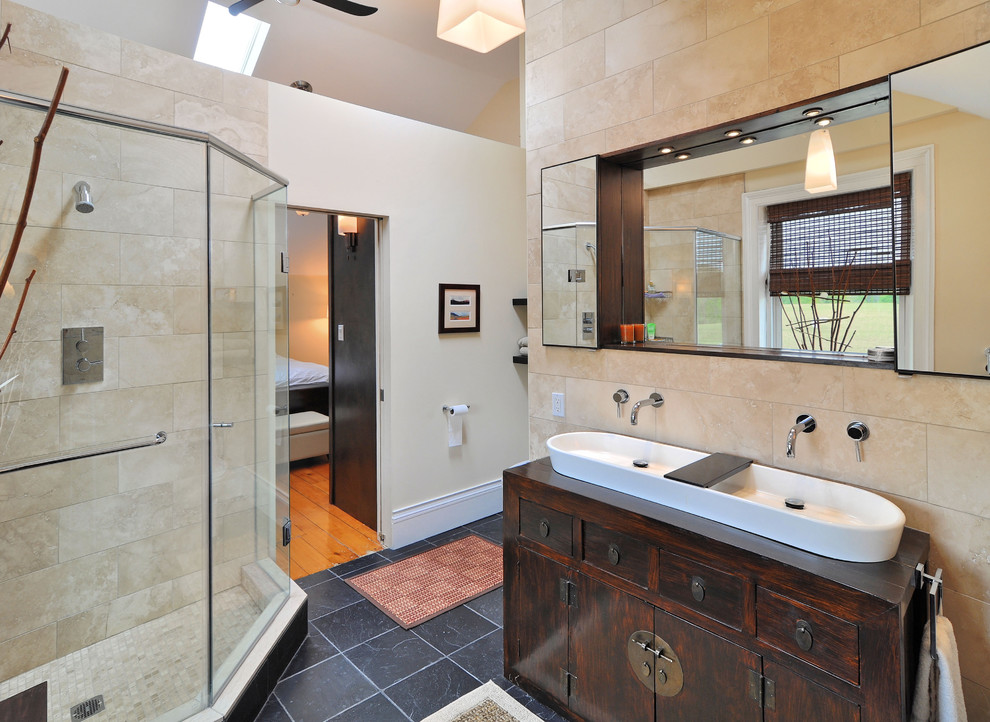 Modelo de cuarto de baño actual con lavabo sobreencimera, ducha esquinera y armarios con paneles lisos