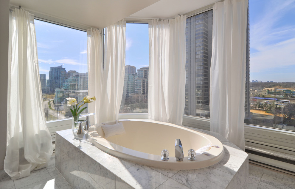 Cette image montre une salle de bain design avec une baignoire posée et un carrelage blanc.