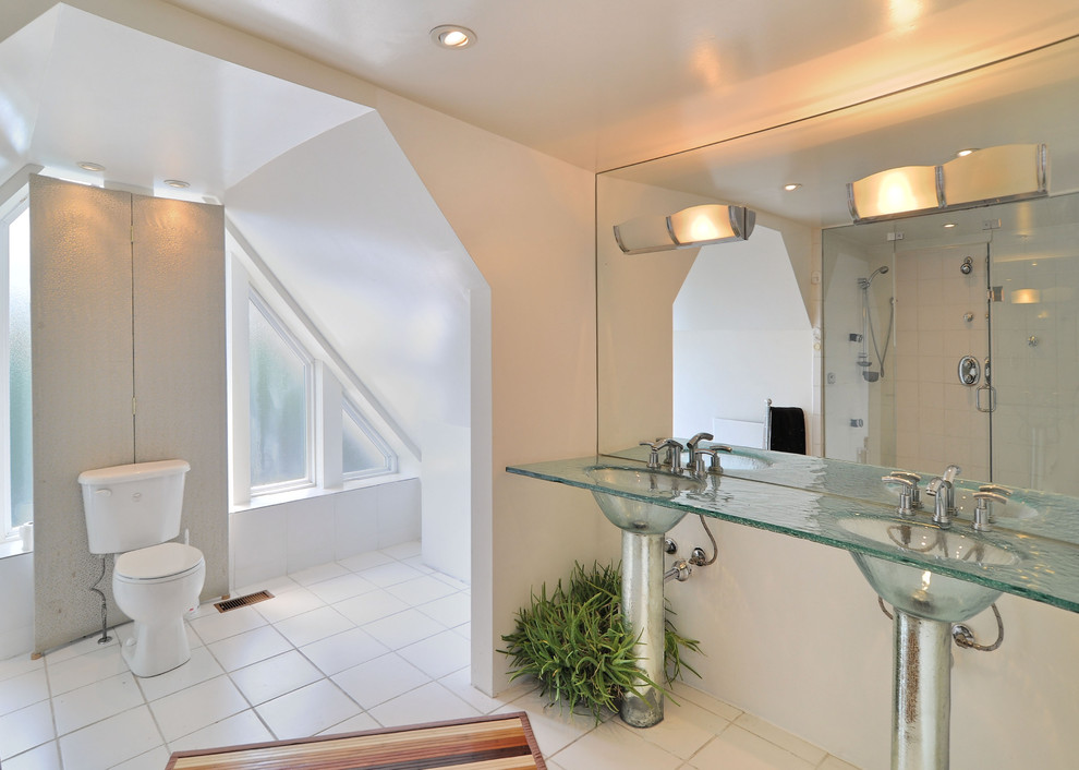 На фото: ванная комната в современном стиле с монолитной раковиной и стеклянной столешницей с