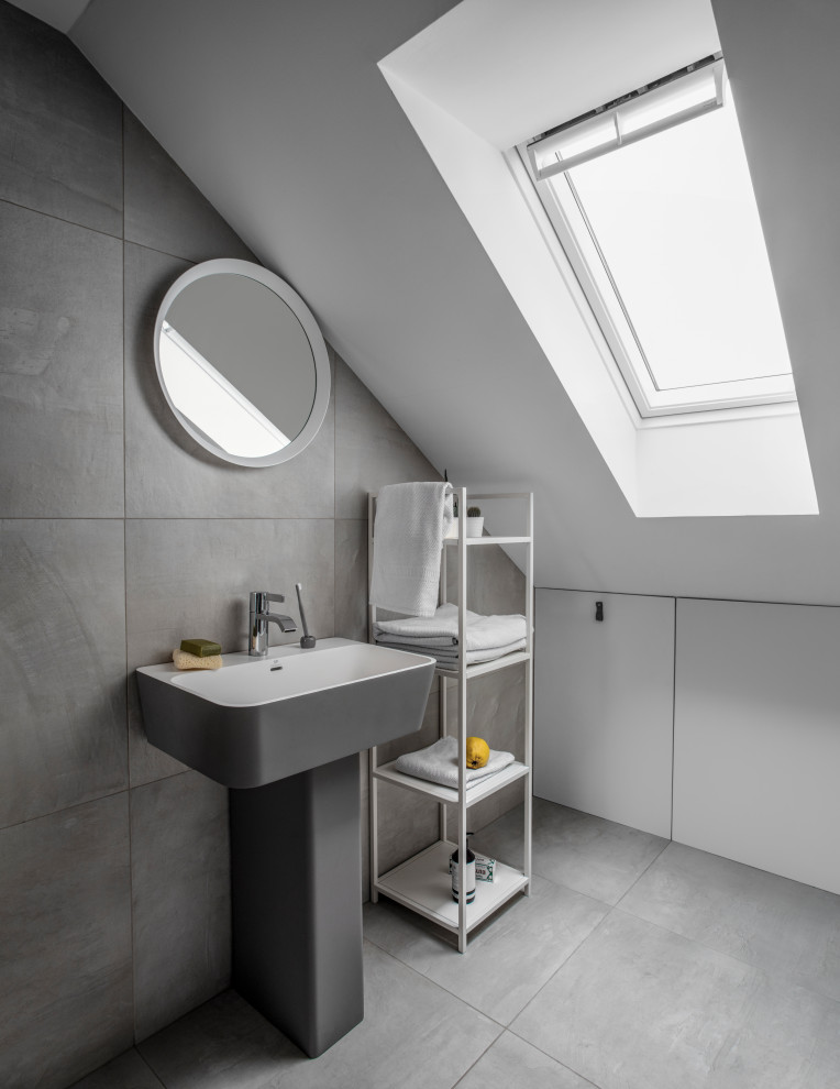 Modern inredning av ett litet vit vitt badrum med dusch, med grå skåp, grå kakel, vita väggar, ett väggmonterat handfat och grått golv
