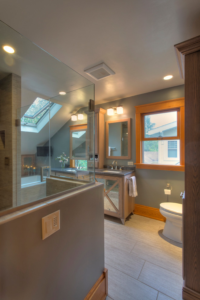 Foto di una stanza da bagno tradizionale di medie dimensioni con lavabo sottopiano, ante lisce, ante con finitura invecchiata, doccia ad angolo, WC monopezzo, piastrelle grigie e pareti blu