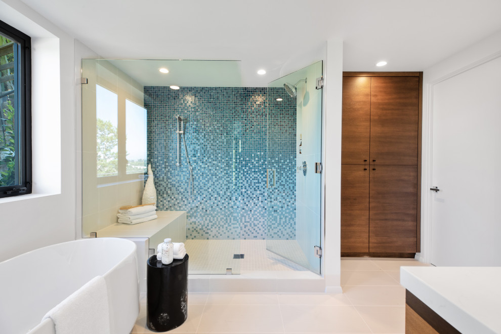 Example of a trendy blue tile and mosaic tile gray floor bathroom design in Los Angeles with medium tone wood cabinets, white walls, a hinged shower door and white countertops