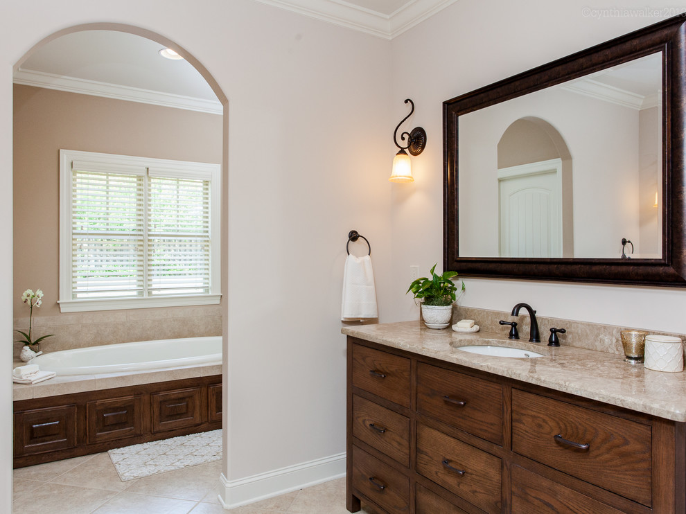 Modelo de cuarto de baño principal clásico con armarios tipo mueble, puertas de armario de madera oscura y encimera de granito