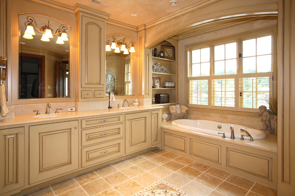 Inredning av ett klassiskt stort en-suite badrum, med luckor med upphöjd panel, beige skåp, ett platsbyggt badkar, beige väggar, klinkergolv i keramik, ett undermonterad handfat, marmorbänkskiva och brunt golv