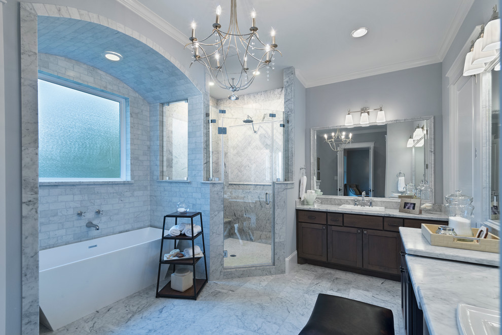Design ideas for a large traditional ensuite bathroom in Houston with shaker cabinets, dark wood cabinets, a freestanding bath, a corner shower, white tiles, stone tiles, grey walls, marble flooring, a built-in sink and marble worktops.