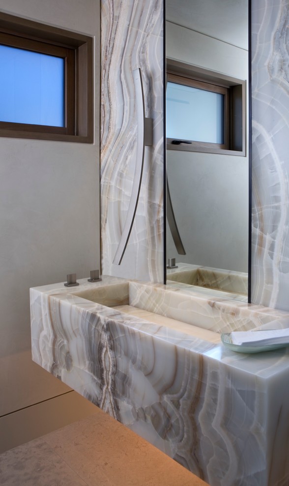 Esempio di una stanza da bagno minimalista con lastra di pietra, lavabo integrato e top in onice