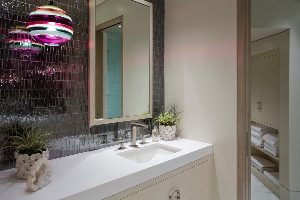 Modernes Badezimmer mit flächenbündigen Schrankfronten, hellen Holzschränken, schwarzen Fliesen, Keramikfliesen, Unterbauwaschbecken und Mineralwerkstoff-Waschtisch in Orange County