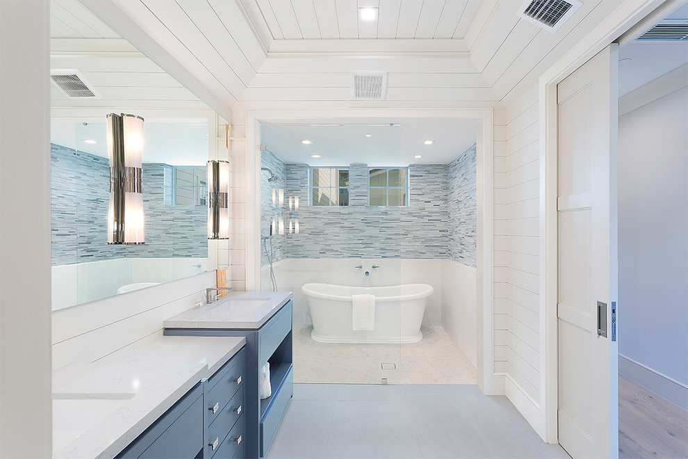 На фото: главная ванная комната среднего размера в современном стиле с плоскими фасадами, синими фасадами, отдельно стоящей ванной, душем в нише, унитазом-моноблоком, разноцветной плиткой, удлиненной плиткой, бежевыми стенами, полом из линолеума, врезной раковиной, столешницей из кварцита, серым полом, открытым душем и серой столешницей