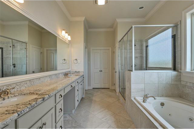 Double shower - large traditional master white tile and ceramic tile ceramic tile double shower idea in New Orleans with recessed-panel cabinets, light wood cabinets, a hot tub, a one-piece toilet, beige walls, an undermount sink and granite countertops