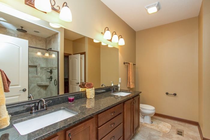 Стильный дизайн: ванная комната в классическом стиле с коричневыми фасадами, душем в нише, раздельным унитазом, бежевой плиткой, керамогранитной плиткой, бежевыми стенами, полом из керамогранита, врезной раковиной и столешницей из гранита - последний тренд