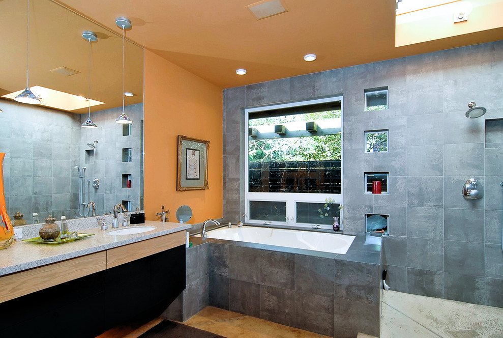 Cette image montre une grande salle de bain principale et beige et blanche minimaliste avec un placard à porte plane, des portes de placard noires, une baignoire encastrée, une douche ouverte, WC séparés, un carrelage gris, des carreaux de céramique, un mur orange, sol en béton ciré, un lavabo encastré, un plan de toilette en granite, un sol beige, aucune cabine, un plan de toilette gris, une niche, meuble double vasque et meuble-lavabo suspendu.
