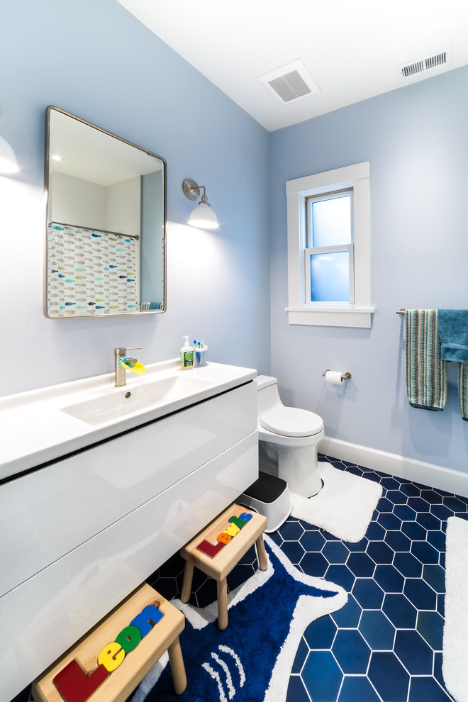 Idée de décoration pour une salle de bain design de taille moyenne pour enfant avec un placard à porte plane, des portes de placard blanches, un mur bleu, un lavabo intégré, un sol bleu, WC à poser, un sol en carrelage de porcelaine et un plan de toilette en quartz modifié.